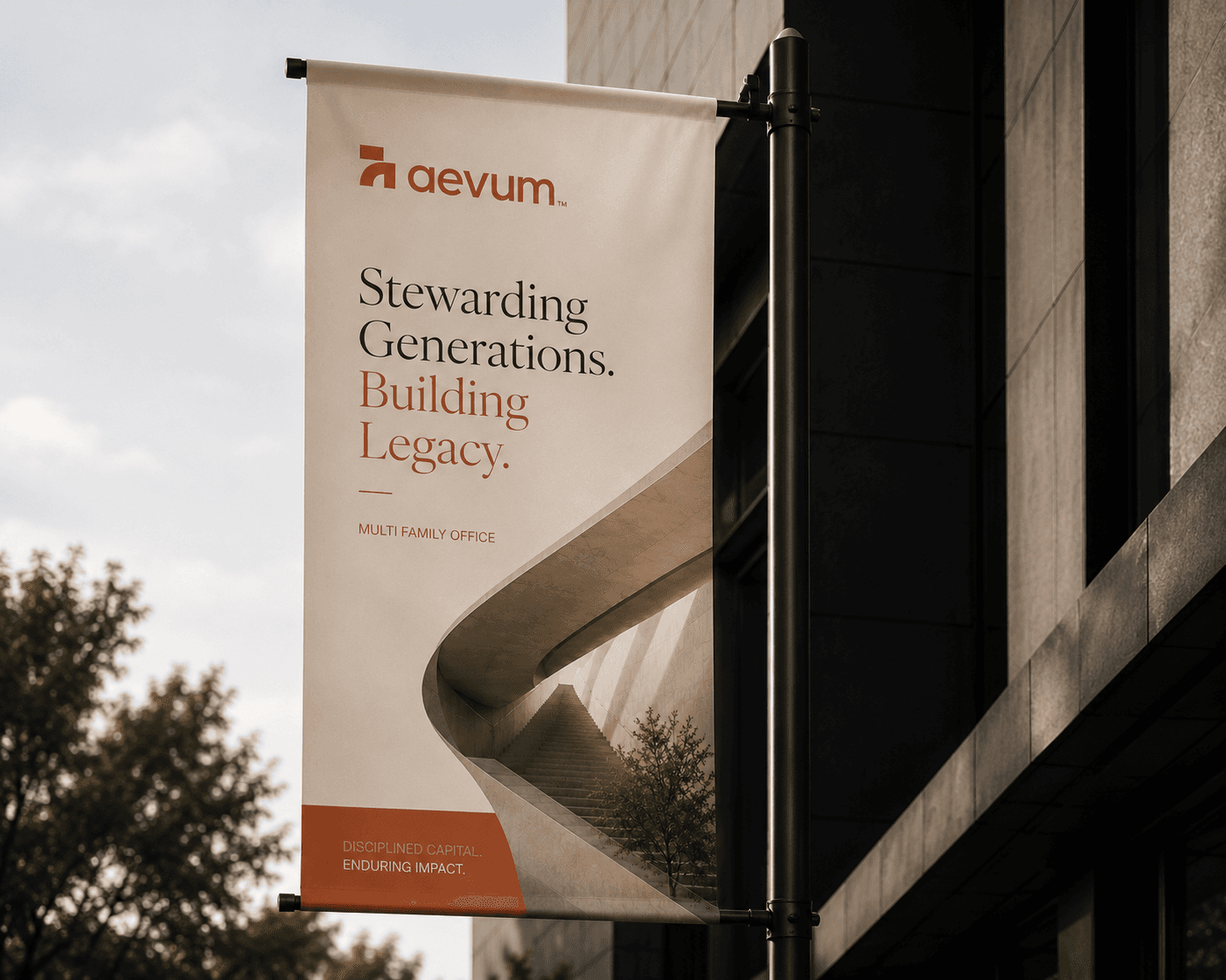 An Aevum street banner on a lamp post reading “Stewarding Generations. Building Legacy.” against a dark stone facade